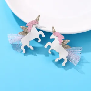 Dettaglio di fermagli per capelli a unicorno con glitter bianchi, paillettes oro e tulle