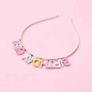 Detail of BIRTHDAY GIRL metal headband with colorful enamel letters on pink background