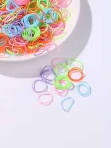 Close-up of colorful elastic hair bands in various macaron colors on a white ceramic plate