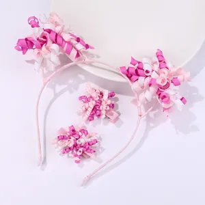 Close-up of pink and white spiral ribbon flower headband and matching hair clips set