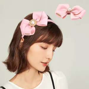 Serre-tête noeud en gros-grain rose avec perle centrale et dentelle dorée