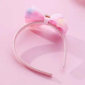Pink glitter headband for kids featuring a large organza bow with colorful plush dots