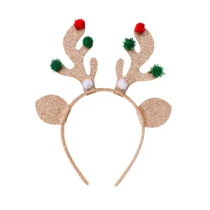 Christmas reindeer antler headband with gold glitter and festive pom poms on white backdrop