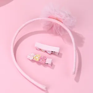 Détail du serre-tête fleur en dentelle rose et ensemble de barrettes cœur à paillettes