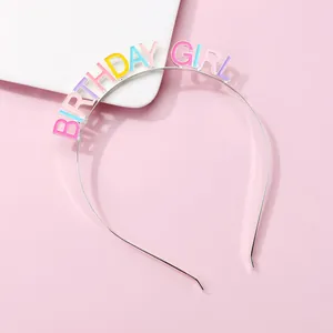 Detailed view of silver birthday girl headband with colorful enamel letters on pink background