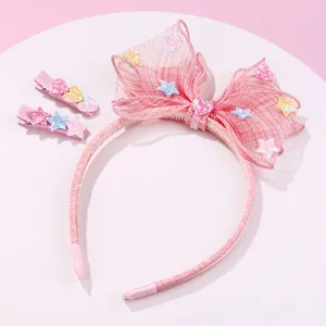 Detailed view of pink mesh bow headband and glittery star hair clip set for girls