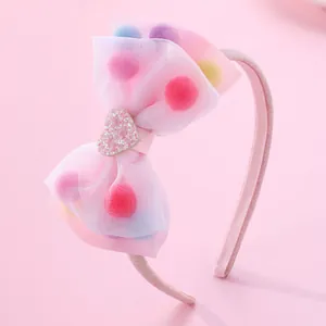 Pink organza bow headband for girls featuring colorful pom-poms and sequin heart detail
