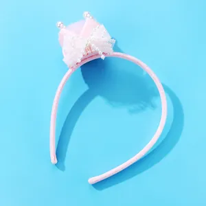 Roze kinderhaardband met kroon, kant en parels op een levendige blauwe achtergrond