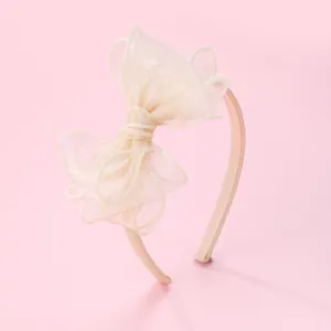 Elegant girls' headband with oversized light beige organza bow and sparkly glitter finish