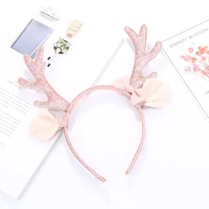Detalle de diadema de astas de reno con lentejuelas oro rosa y lazo de satén rosa