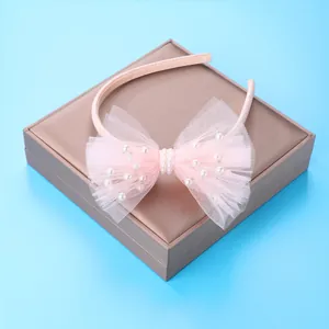 Pink mesh bow headband for girls featuring delicate white pearls and fabric wrapping