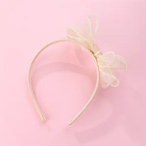 Detail of sweet organza bow headband with textured stripes on a soft pink background