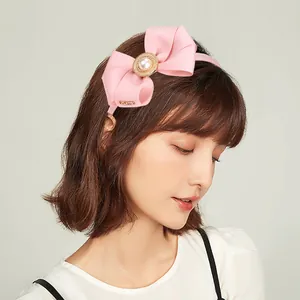 Détail du bandeau rose à nœud côtelé avec perle et lettrage Loveme en métal doré