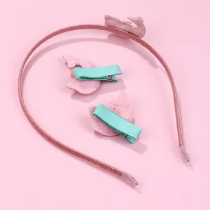 Süßes rosa Haarreif-Set mit grünen Delphin-Haarklammern auf rosa Hintergrund