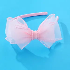 Serre-tête rose avec nœud en maille double épaisseur et perles sur fond bleu vif