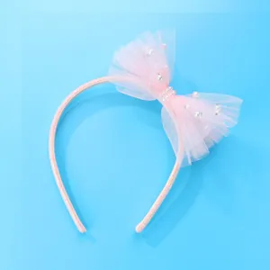 Detailed view of pink tulle bow headband with white pearls and sparkling rhinestones