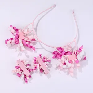 Detailed view of pink and white curly ribbon flower hairband and matching clips for girls
