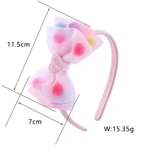 Pink bow headband detail showing dimensions 11.5cm by 7cm with colorful pompoms inside