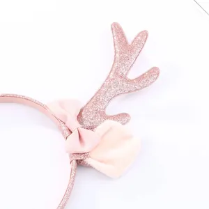 Detalle de cuernos de reno rosa con lentejuelas, lazo y piel sintética para niños