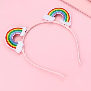 Pink girls headband featuring cute rainbow and cloud embroidery on a soft fabric base