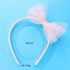 Detail of pink mesh bow headband with white pearls and glitter finish for girls
