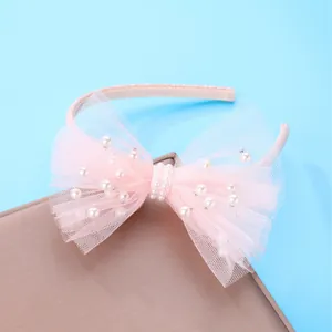 Pink mesh headband for girls with a large bow and white pearls on blue background