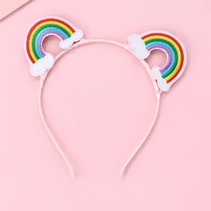 Close-up of pink fabric headband featuring sweet embroidered rainbow and cloud details