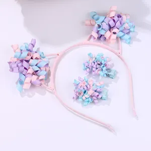Detail view of pink and purple floral ribbon cat ear headband and matching hair clips set