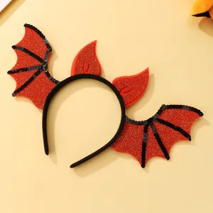 Detail of Halloween headband with red glitter bat wings and horns on orange background