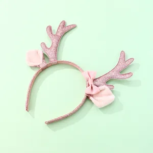 Primer plano de diadema rosa de reno navideño con astas brillantes y orejas suaves