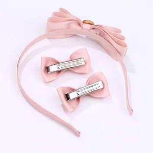 Pink ribbon bow headband and clip set with gold embossed detail on white background