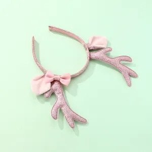 Detalle de diadema de cuernos de reno rosa brillante con orejas de peluche y un lazo rosa