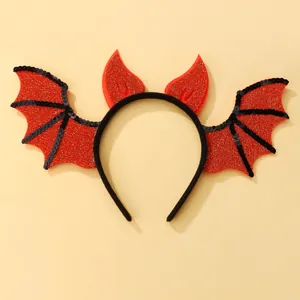 Close-up of Halloween headband featuring glittery red devil horns and black bat wings