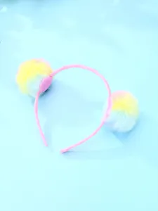 Gros plan d'un serre-tête pour enfants avec pompons en peluche dégradés arc-en-ciel