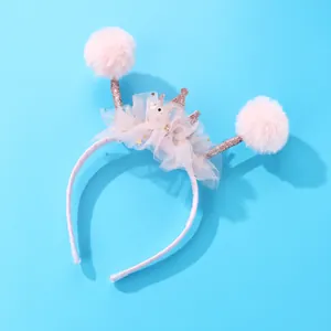 Dettaglio di palline di peluche rosa e corona in tulle su cerchietto per bambini