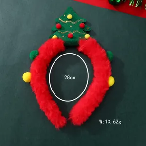 Detail view of a plush red Christmas headband with a green felt tree and festive pom-poms