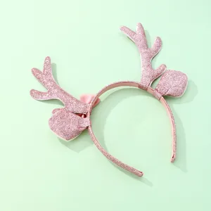 Detalle de la diadema de reno navideña rosa con cuernos brillantes y un lazo