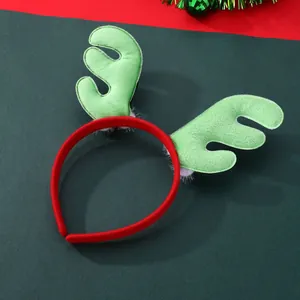 Detail von rotem Weihnachts-Rentier-Haarreif mit grünen Samtgeweihen und weißem Plüsch