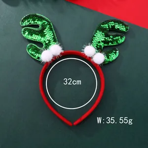 Detail von Weihnachts-Rentier-Haarreif mit grünen Pailletten und weißen Plüschbällen