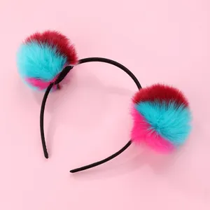 Close-up of vibrant tricolor plush pom-poms on a slim non-slip headband for girls