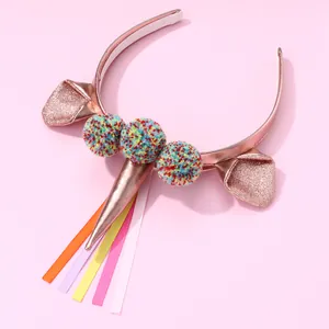 Unicorn headband for kids with shiny pink gold ears and colorful rainbow pom poms