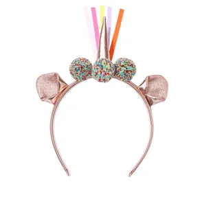 Rose gold unicorn headband featuring colorful plush pom-poms and shiny sequined ears