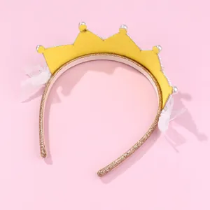 Detail van gele prinsessenkroon haarband met gouden glitter, parels en witte kant