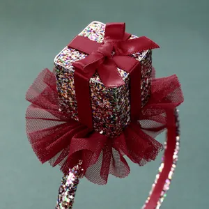 Detail of red mesh flower headband with sequined gift box and satin ribbon bow