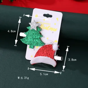 Detailed size view of glitter Christmas tree and hat hair clips on a festive paper card