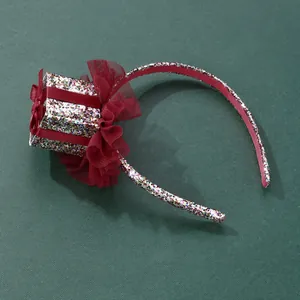 Detail of sequined Christmas headband featuring a red gift box and organza flower trim