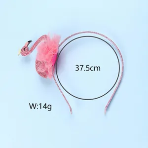 Détail d'un serre-tête flamant rose pailleté avec fleurs en tulle et couronne dorée