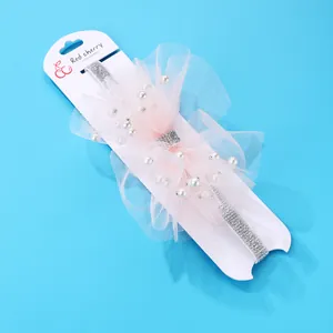 Pink layered tulle baby headband with white pearl accents on silver glitter elastic band