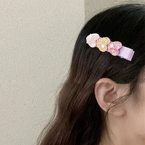 Detail showing the girl wearing the glitter heart hair clip with three colorful sequins