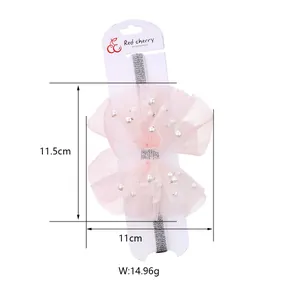 Detail of pink mesh bow headband with white pearls and silver glitter texture strap